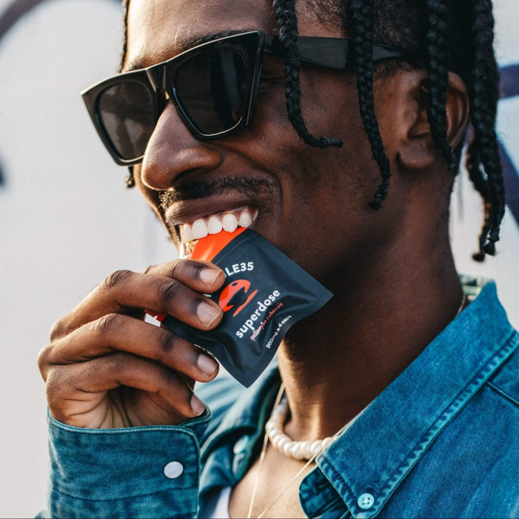 Man opening a pack of S35 Superdose shroom-infused capsules. 