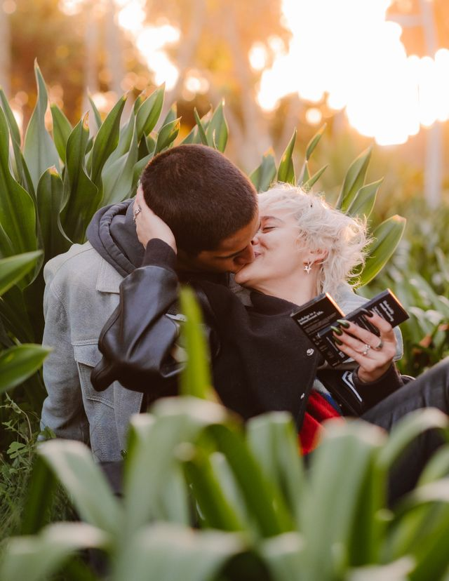 couple kissing while taking shroom-infused chocolate bars in the garden. 