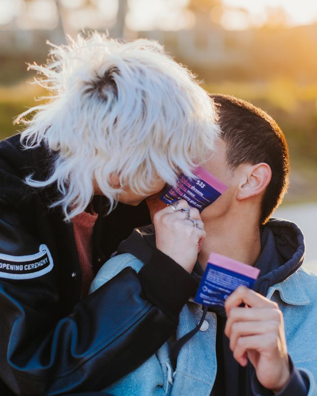 Couple kissing with shroom capsules in hand. 